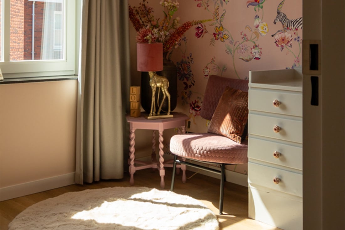 Roze meisjes kinderkamer wit zacht vloerkleed roze behang met bloemen roze fauteuil