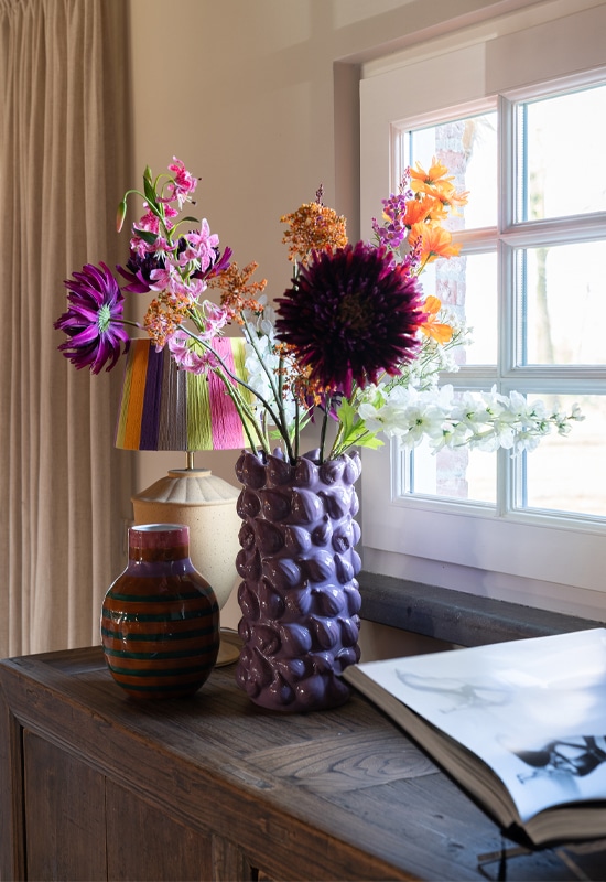 Uniek kleurrijke accessoires op houten dressoir