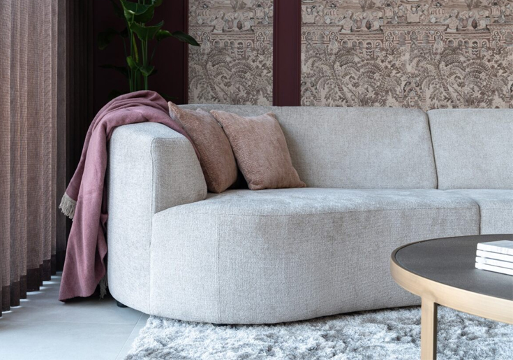 Beige bank rond met roze sierkussens